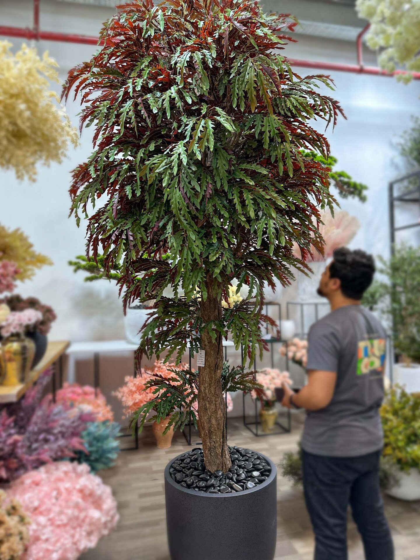 9742(1) Discover the beauty of our artificial tree leaves in dark green-bronze and red, perfect for adding grandeur to any environment. Shop now!
